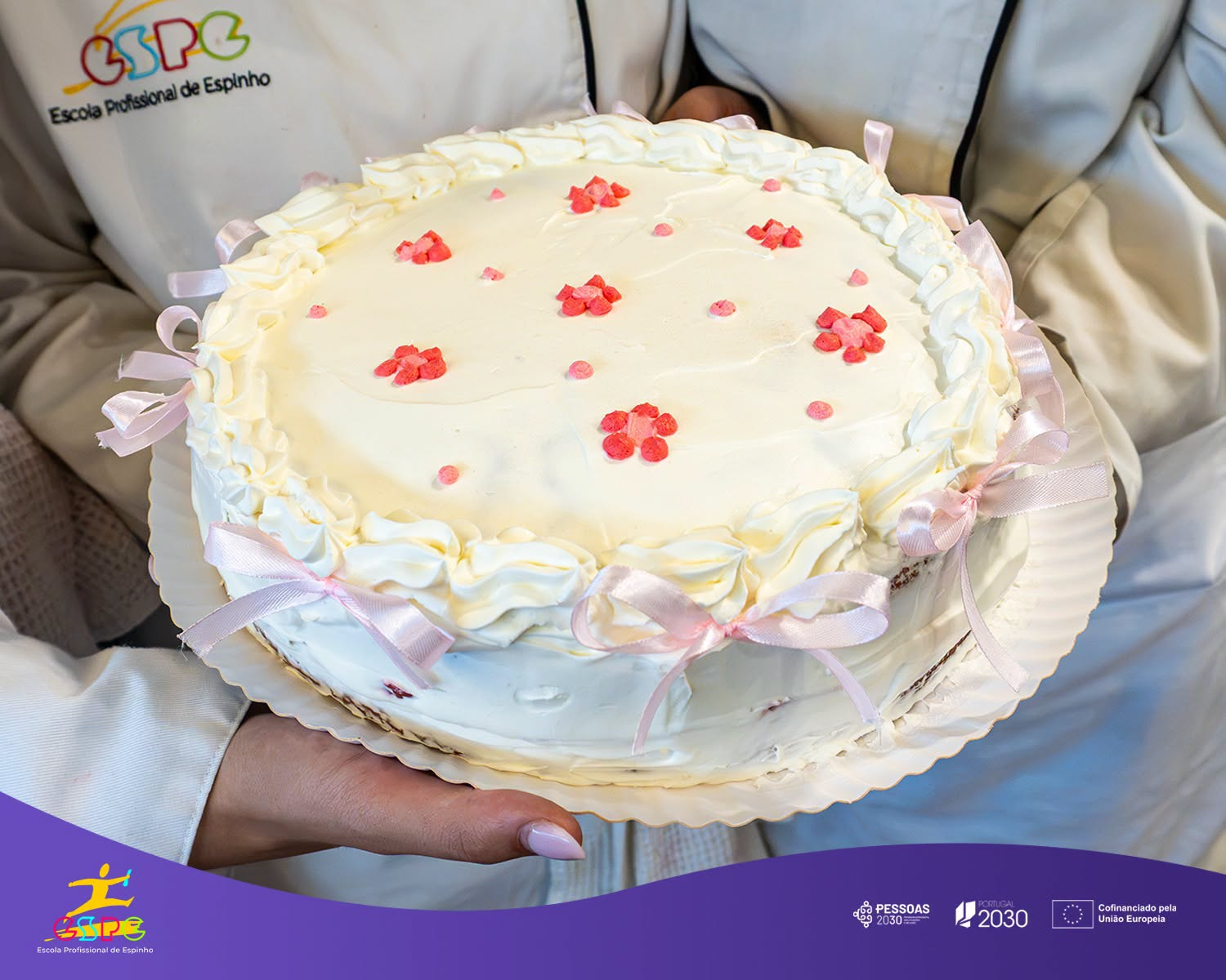 Bolo decorado com flores cor-de-rosa e laços